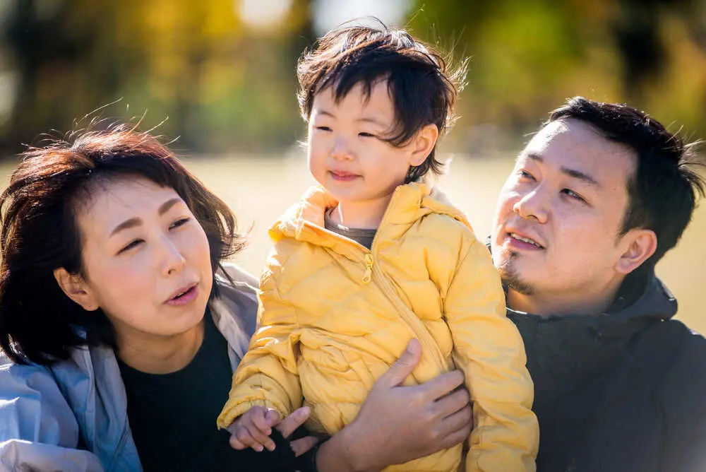 父母在戶外抱著幼兒說話互動