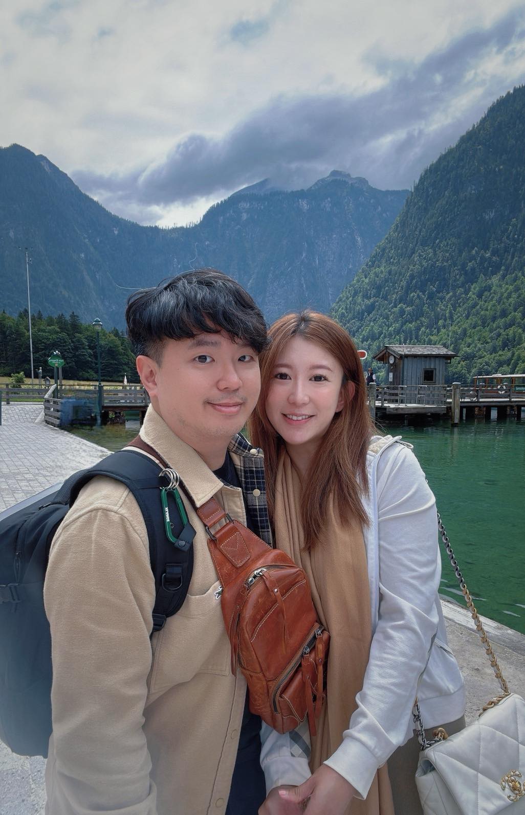 一對伴侶在高山湖泊前微笑合影